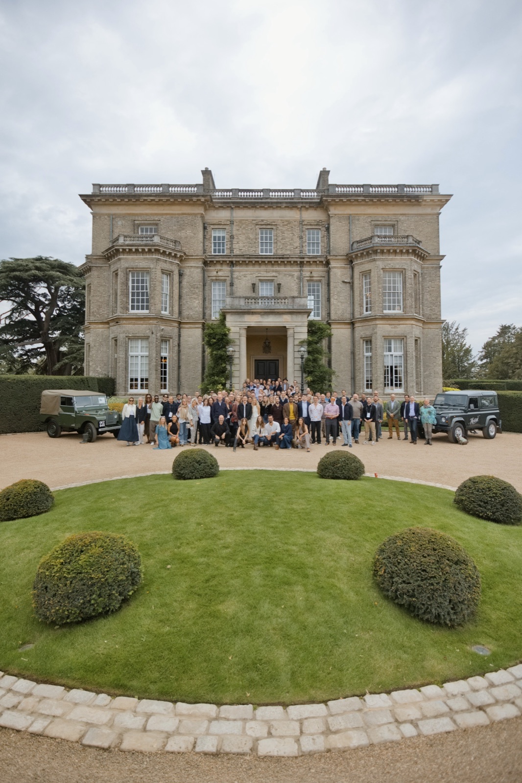 The Hedsor Hundred school photograph: one hundred guests on the gravel before Hedsor House, flanked by two Land Rovers