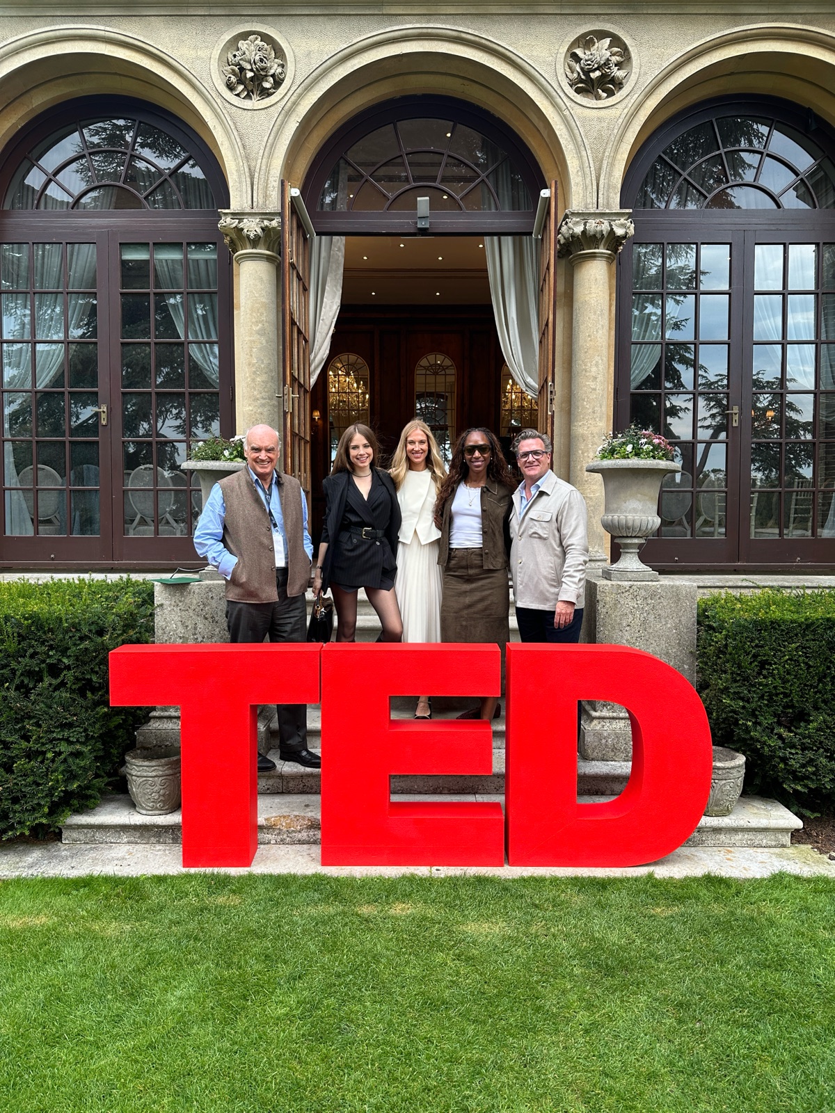 Xenia Tchoumi with Vanessa Kingori OBE, David Kidder and host Rosie Shephard at the red TED letters before Hedsor House during The Hedsor Hundred 2026